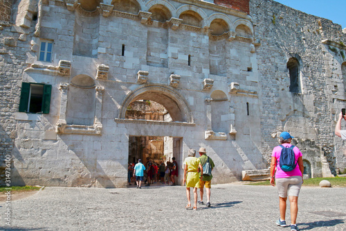 Split / Croatia - June 26, 2019: Tourists entering ancient Golden Gate to the Diocletians Palace section of Old Town Split, Croatia.