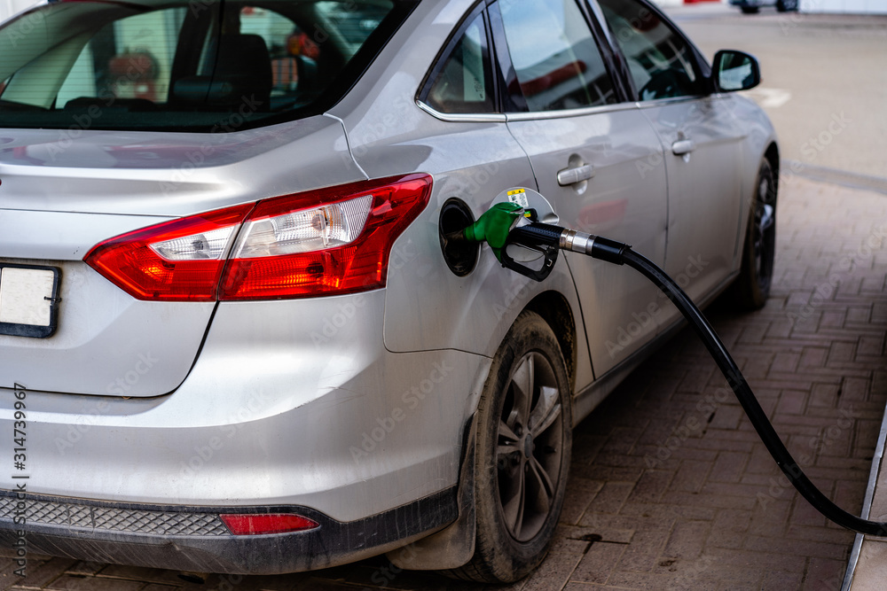 Fototapeta premium Refueling the machine from a hose at a gas station