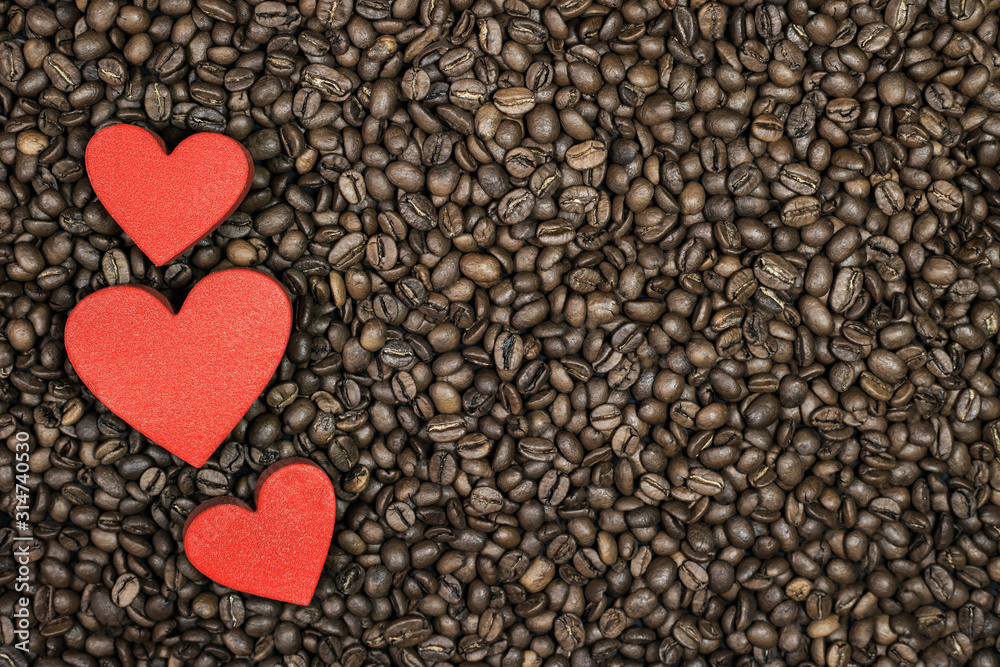 Roasted coffee beans and three red hearts. Full frame. Roasted coffee beans and three red hearts. Full frame.