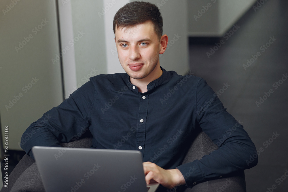 Handsome man in a black suit. Businessman working in a office Handsome man in a black suit. Businessman working in a office