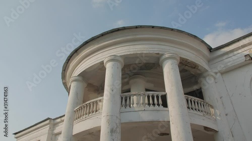 Old abandoned palace mansion house ruined facade exterior white two-story building Renaissance architecture style with columns at sunset Palace of Earl Xido in Khmelnik Ukraine photo