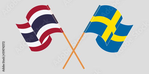 Crossed and waving flags of Thailand and Sweden