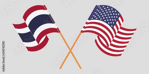 Crossed and waving flags of Thailand and the USA