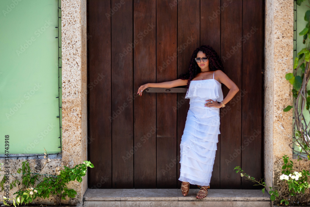 Beautiful local Colombian woman in white dress in the walled city of Cartagena, Colombia