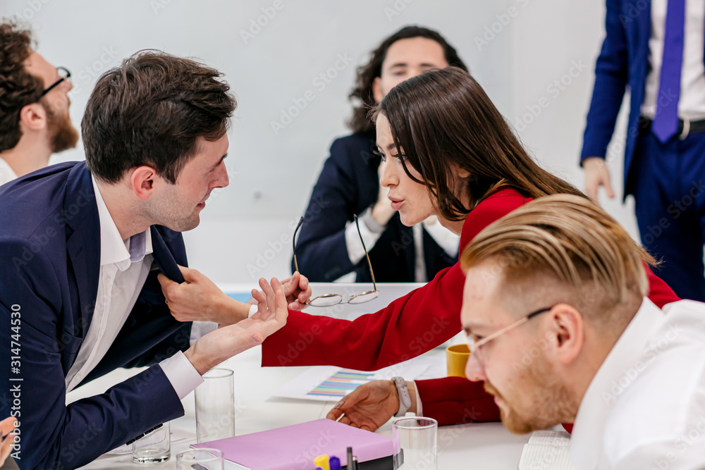 Obraz premium unhappy caucasian people worried about troubles, having finance problems at work, everyone lose their nerves because of deadline. furious young woman in red blazer grabbed colleague by tie