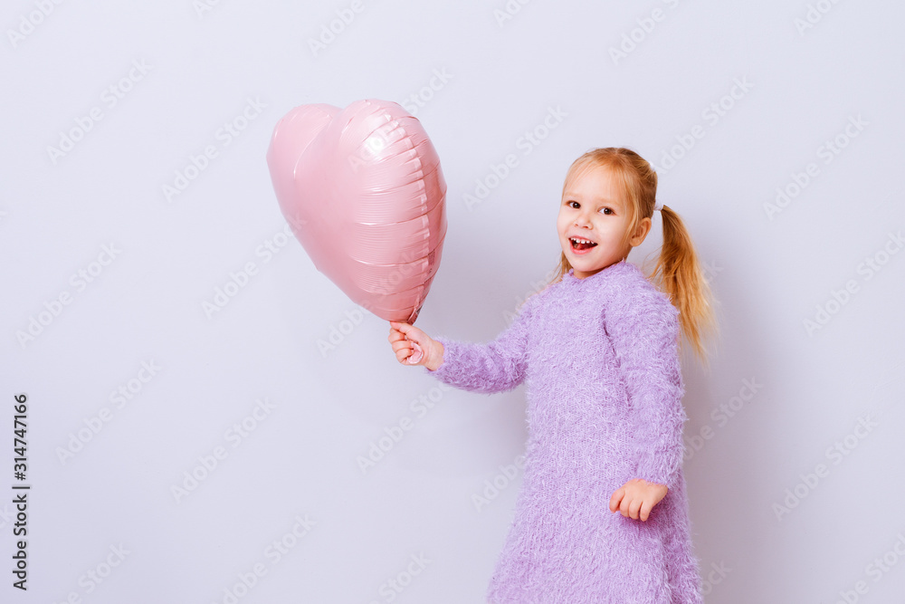 Happy valentines day heart. Baby girl smiling with pink balloon heart on light-violet background