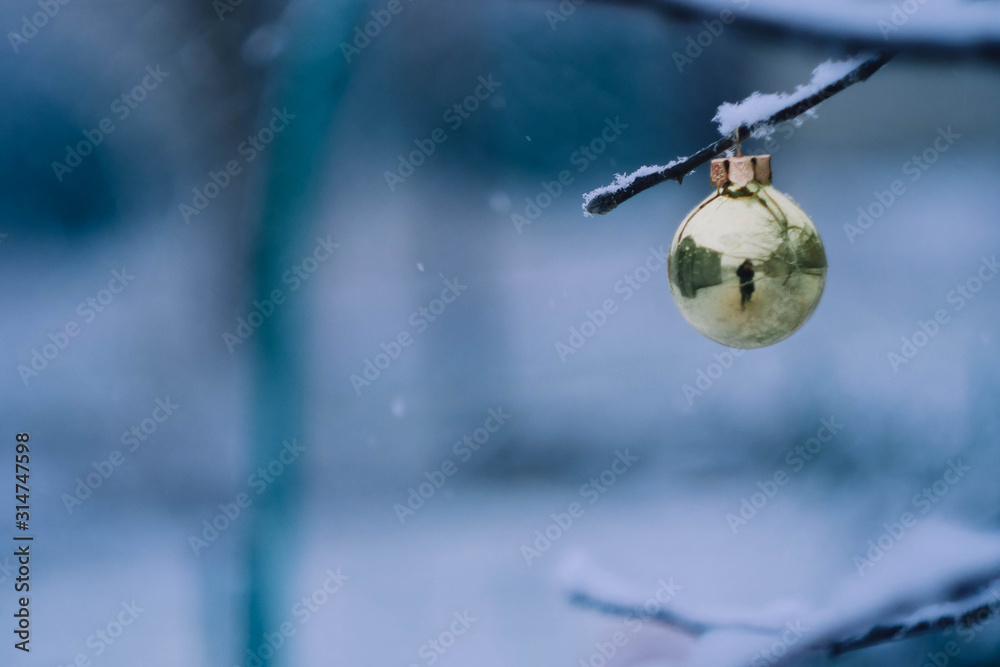 Green Christmas ball decor hanging on the tree branch. Copy space. Winter wallpaper 