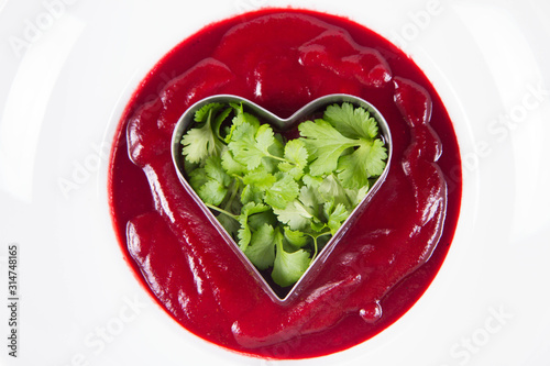 Beetroot cream soup with a heart made of coriander being made - a romantic treat