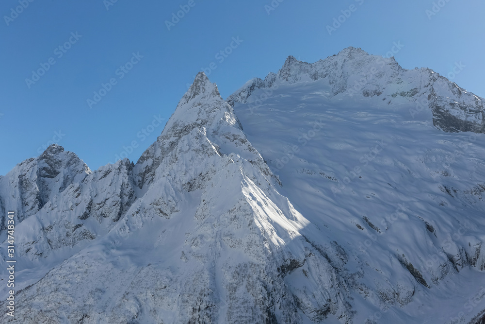 Snowy peak in the Caucasus mountains. Mountain landscape. Beautiful nature in the mountains. Travel and hike.