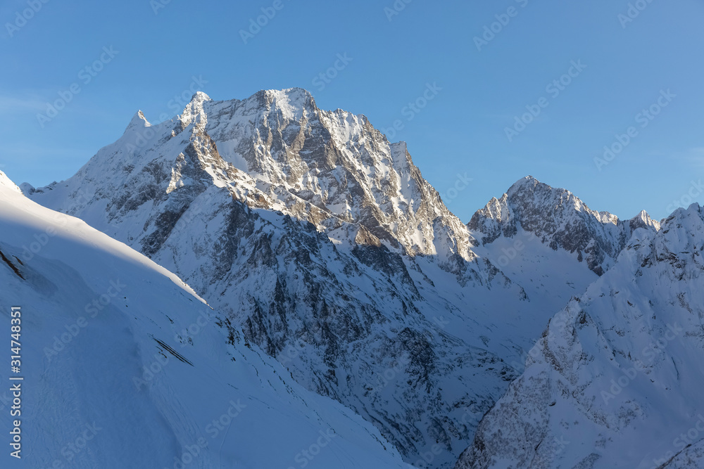 Snow top Dombay-Ulgen in the Caucasus mountains. Mountain landscape. Travel and hike.