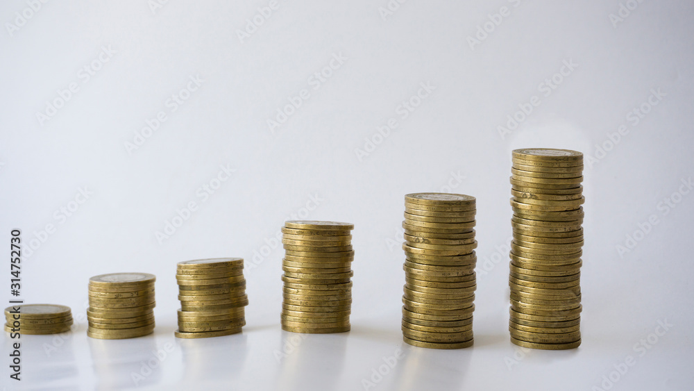 Saving and growth concept with metal coins isolated on white background. Saving money for education, summer holiday vacation, new house, new entrepreneurship or basic needs loan. Step by step. Saving and growth concept with metal coins isolated on white background. Saving money for education, summer holiday vacation, new house, new entrepreneurship or basic needs loan. Step by step.