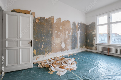 Fotografie old room during renovation removing wallpaper -