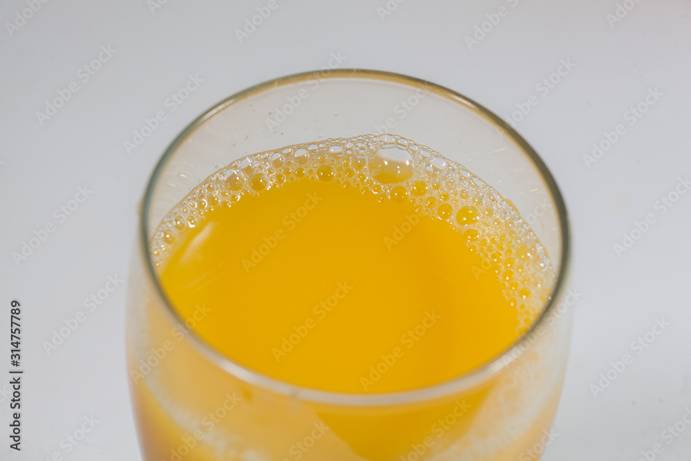 Glass with orange juice on a white table. Glass with orange juice on a white table.