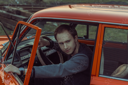 young man in oldschool car