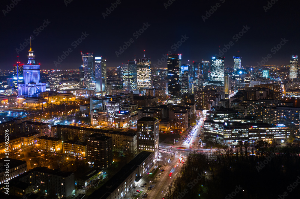 Warsaw-Poland 04. December. 2019. Aerial view of luminous high-rise buildings of the business center with lighted windows located in Warsaw against the evening sky. Warsaw-Poland 04. December. 2019. Aerial view of luminous high-rise buildings of the business center with lighted windows located in Warsaw against the evening sky.