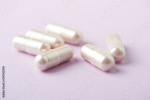 Carnitine capsules. Concept for a healthy dietary supplementation. Bright paper background. Soft focus. Close up.