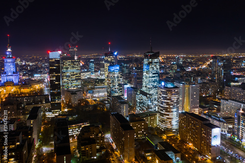 Warsaw-Poland 04. December. 2019. Aerial view of luminous high-rise buildings of the business center with lighted windows located in Warsaw against the evening sky. 