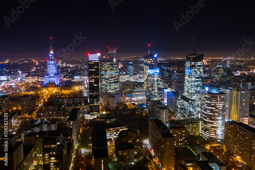 Warsaw, Poland. 03. December. 2019. Drone shot at night metropolis with skyscrapers and buildings. Aerial view of the business center at night in winter. Warsaw,