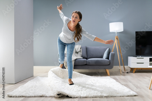 Woman Legs Stumbling With A Carpet photo