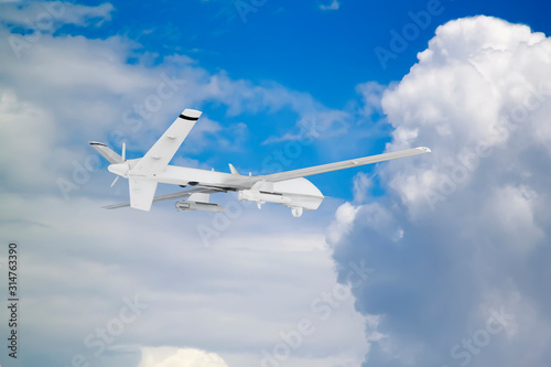 military RC military drone flies against the backdrop of blue peaceful sky with white clouds