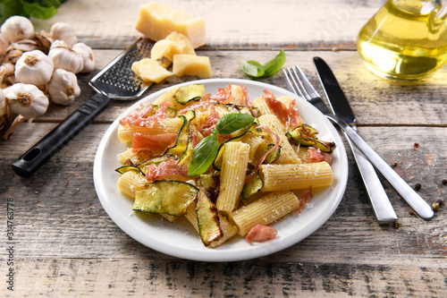 Tasty rigatoni pasta with courgette, prosciutto ham and grana padano cheese