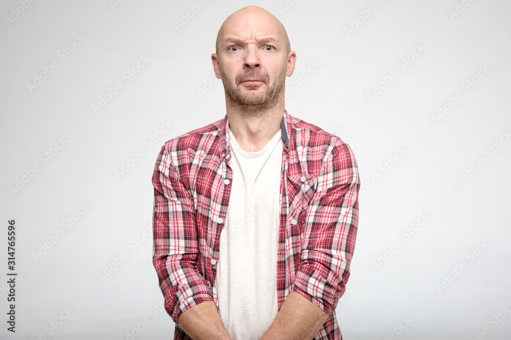 Bald man is guilty, he was exposed. He's scared, stares at the camera and standing still. Bald man is guilty, he was exposed. He's scared, stares at the camera and standing still.