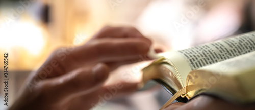 Foto Man's hands over the Bible, against the background of the living room