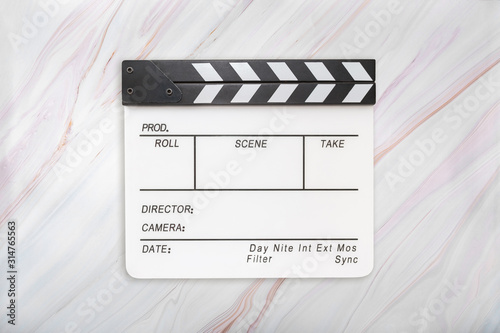 Flat lay of white clapboard on marble background. Clapper board on marble texture. Top view photo