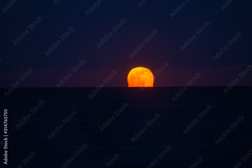 full moonrise over the sea at night