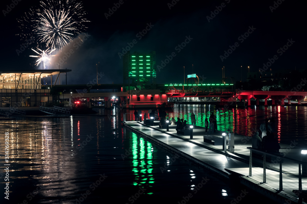  New Year's fireworks in the city. View of the floating pier and High School Rowing Club from  Julian B. Lane Riverfront Park. Tampa, Florida, USA
