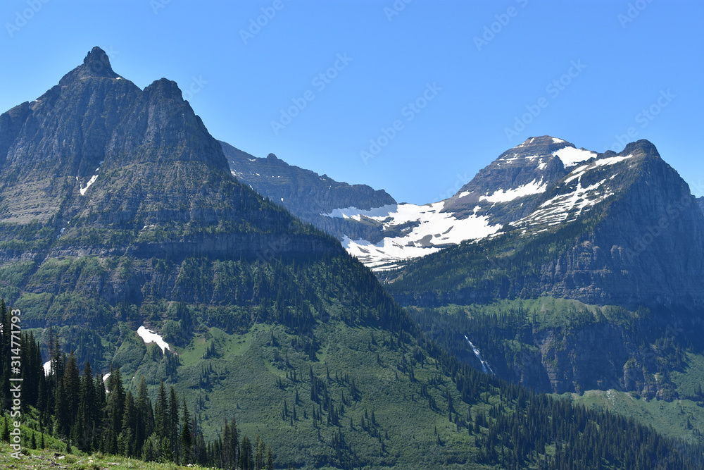 Valley Between Snow Dusted Mountains with Hidden Waterfall, Going-to-the-Sun Road, Glacier National Park, Montana Valley Between Snow Dusted Mountains with Hidden Waterfall, Going-to-the-Sun Road, Glacier National Park, Montana