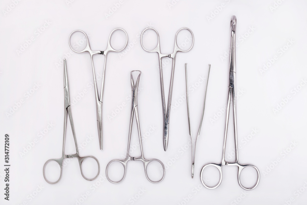 Set of surgical instruments on white background. Flat lay of surgical scissors and clamps Set of surgical instruments on white background. Flat lay of surgical scissors and clamps