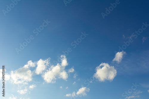 Clear blue sky with clouds for background picture. © Alexlekky