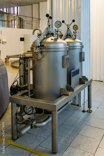 Manometer on the cylinder with gas in and hop dispenser in modern brewery. Close-up