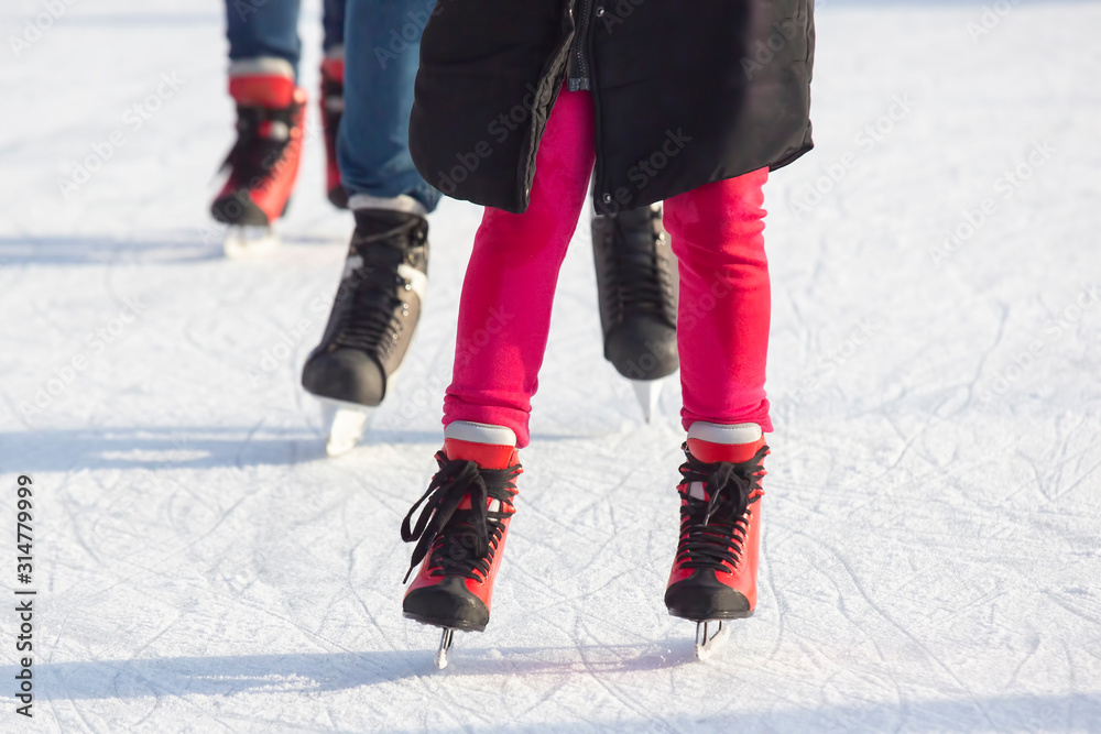 different people are actively skating on an ice rink different people are actively skating on an ice rink
