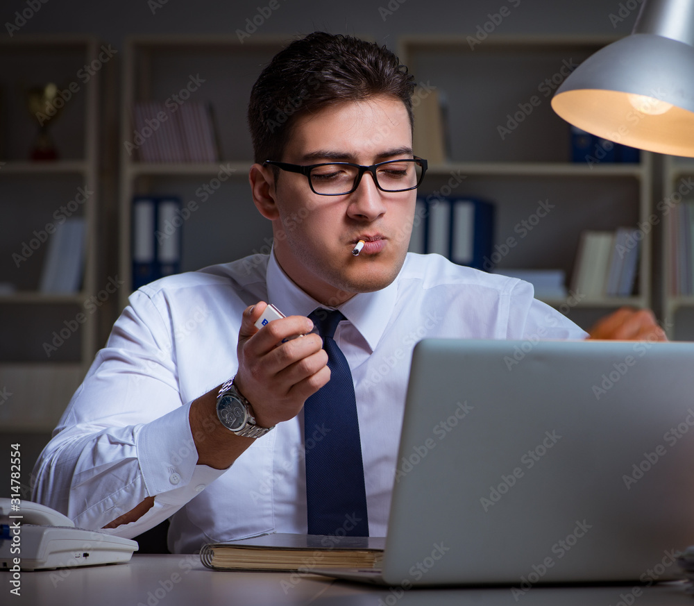 Businessman under stress smoking in office Businessman under stress smoking in office