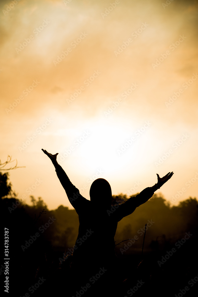 A woman accompanied by a sunset over the jungle.