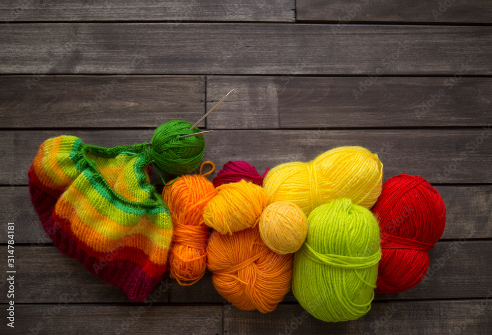 Yarn for knitting rainbow. Wood background. - obrazy, fototapety, plakaty 