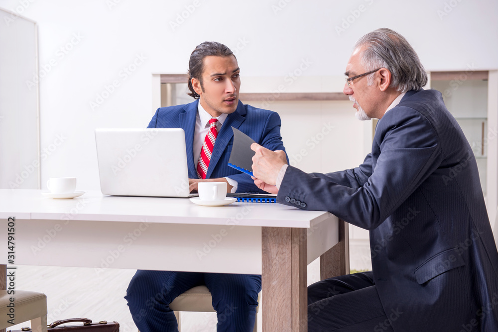 Two businessman discussing business in office Two businessman discussing business in office