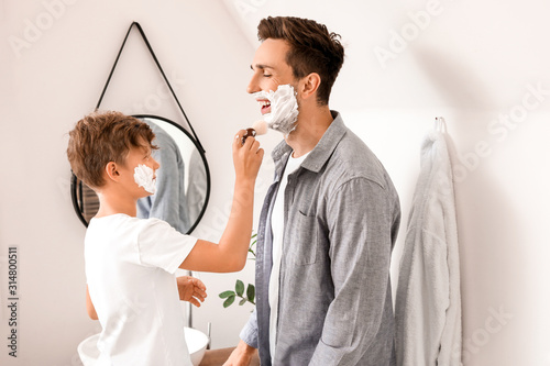 Young boy applying shaving ...