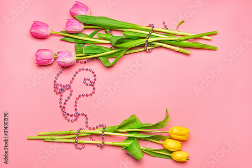 Beautiful tulip flowers with beads on color background