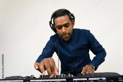 Male DJ playing music on white background