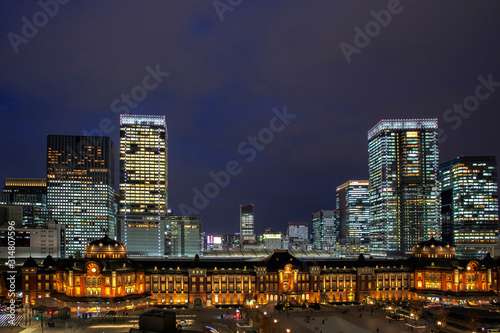 Tokyo Railway Station  beautiful urban cityscape surrounding by modern high-rise buildings in Marunouchi business district  during twilight against cloudy sky.