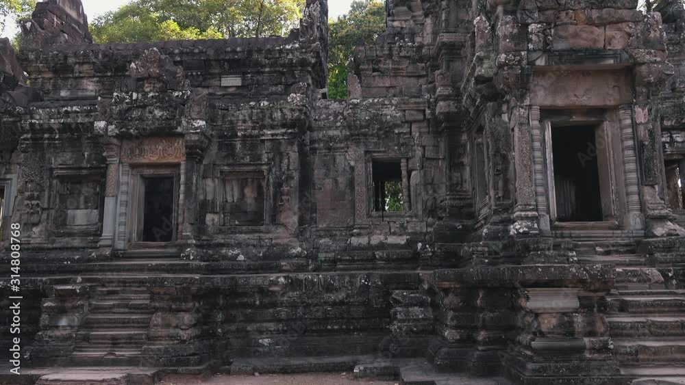 Wide Exterior Panning of an Ancient Temple With its Stairs and Doorways Surrounded by Trees Near Angkor Wat Wide Exterior Panning of an Ancient Temple With its Stairs and Doorways Surrounded by Trees Near Angkor Wat