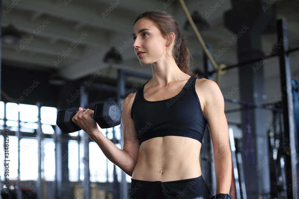 Muscular fit woman exercising building muscles at gym. Muscular fit woman exercising building muscles at gym.
