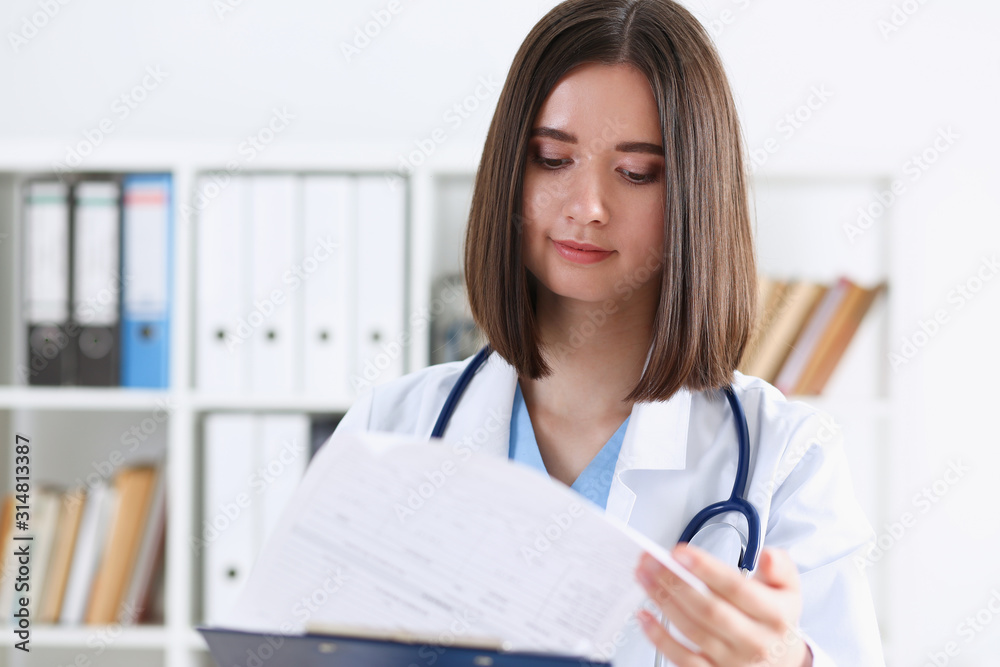 Female medicine doctor hand holding silver pen looking in clipboard pad closeup. Ward round patient visit check 911 medical calculation and statistics concept. Physician ready to examine patient Female medicine doctor hand holding silver pen looking in clipboard pad closeup. Ward round patient visit check 911 medical calculation and statistics concept. Physician ready to examine patient