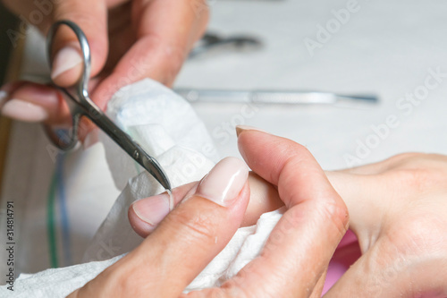 Cutting a cuticle in a beauty salon. Close-up
