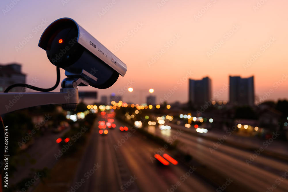 CCTV, Surveillance camera operating in city watching traffic road with beautiful twilight sky