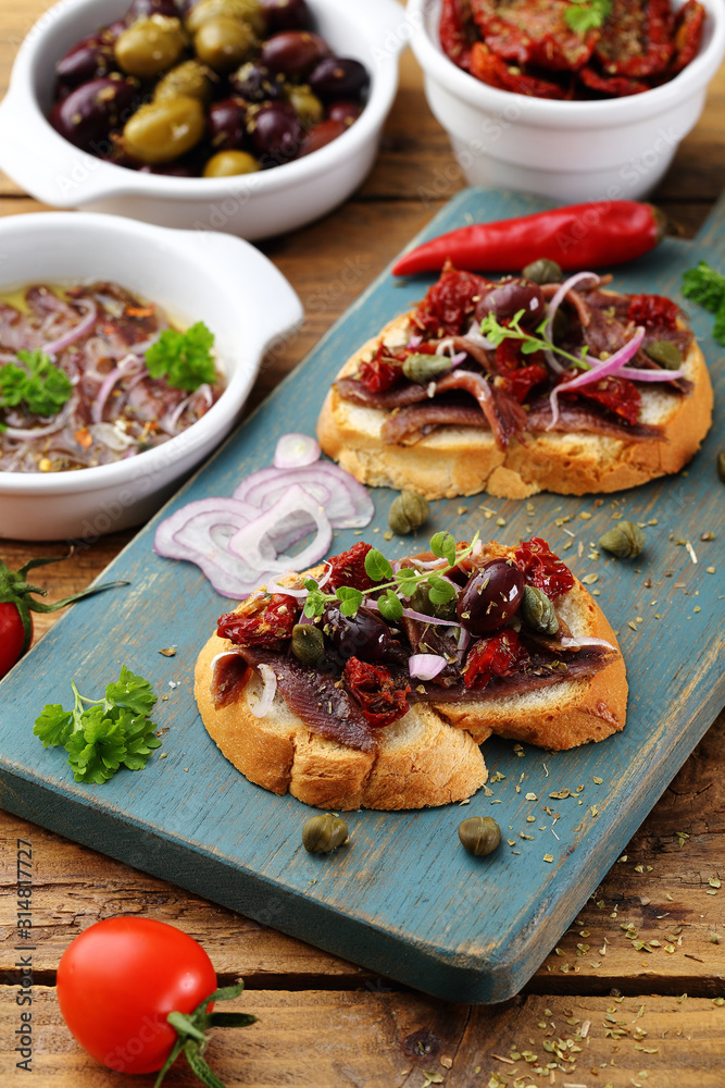 cibo mediterraneo spunti con acciughe pomodori secchi olive sfondo rustico cibo mediterraneo spunti con acciughe pomodori secchi olive sfondo rustico