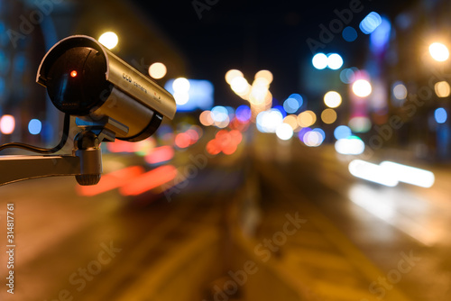 CCTV, Surveillance camera operating in city watching traffic road at night
